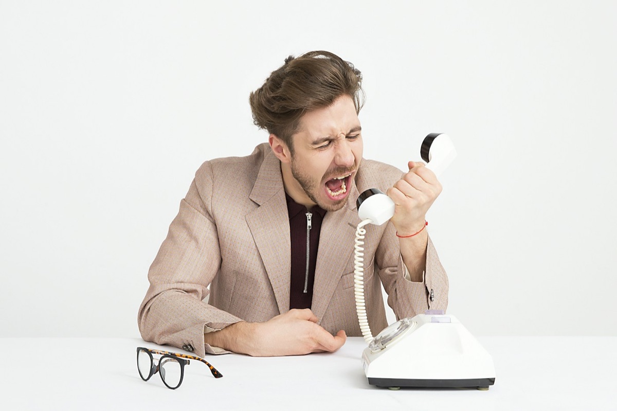 A man shouting down a telephone